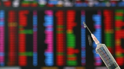 Syringe fill with covid-19 vaccine with stock exchange board background , concept vaccine can help economic recovery. - Powered by Adobe