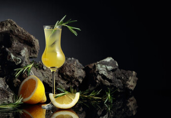 Traditional homemade lemon liqueur limoncello on the black background.