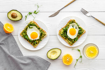 Eggs and avocado with spinach on toasted bread. Top view