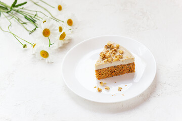 A slice of carrot cake with walnuts without baking on the table.