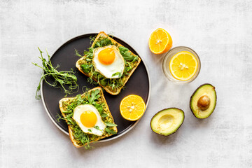 Fototapeta na wymiar Open sandwich with avocado spinach cream and eggs. Top view