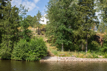 VYBORG, Leningrad REGION, RUSSIA-JULY, 19, 2021: view of the white stone chapel of Ludwigsburg on Ludwigstein Island and the green foliage of trees on a summer cloudy day in Monrepos Park