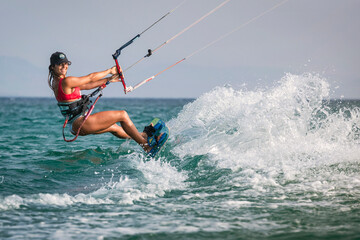 Mujer atlética con visera practicando kitesurf en la playa de Tarifa, Provincia de Cádiz, Andalucía, España