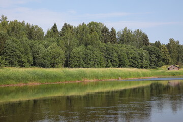 Fototapeta na wymiar River landscape with a sauna on the shore
