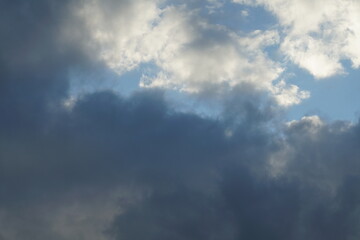 Naklejka na ściany i meble Wolken Himmel mit blau, grau, weiß und beige nach einem Regen Schauer