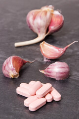 Garlic and medical pills, tablets or supplements, natural treatment of diseases concept