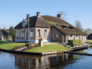 Fototapeta na wymiar Centuries-old thatched-roof houses in Giethoorn, Steenwijkerland, Overijssel Province, The Netherlands