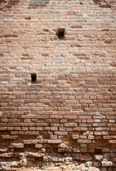 Ruins of an ancient castle. Destroyed brick walls with loopholes. History of ancient architecture. Brick old background