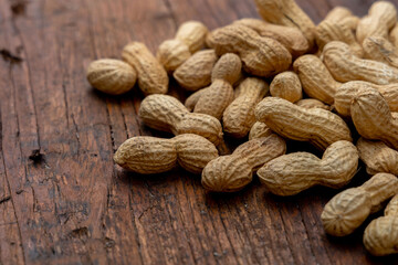 A lot of penuts on wooden background