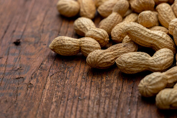 A lot of penuts on wooden background