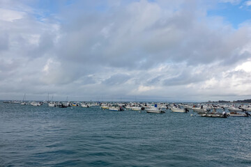 Ocean with rows of moored boats on the water surface against the background of the horizon.