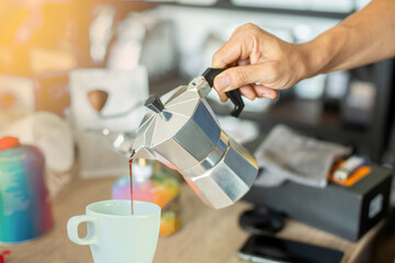 Pour the coffee from the kettle into the glass.