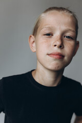 Naklejka premium Handsome blonde freckled guy isolated on grey background. Teenager stylish emotional portrait 