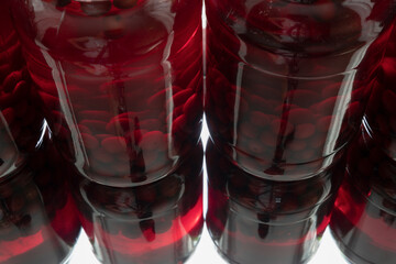 Glass jars with preserved red cherries top and side view