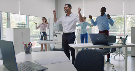 Group of happy young diverse businesspeople doing stretching exercise in office