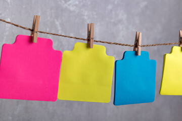 Blank varicoloured paper cards hang with clothespin on rope. Copy space. Place for your text.