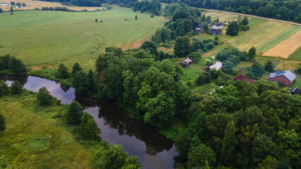 Aerial landscape of winding river in green field, top view of beautiful nature background from drone, seasonal summer landscape with copy space.