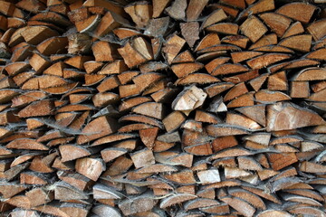 Wood pile reserve for the winter. Pile of chopped firewood. Background texture wood. Wood chips
