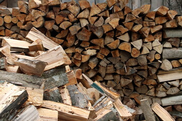 Wood pile reserve for the winter. Pile of chopped firewood. Background texture wood. Wood chips