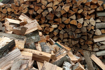 Wood pile reserve for the winter. Pile of chopped firewood. Background texture wood. Wood chips