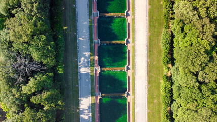 Reggia di Caserta, Italy. Aerial view of famous royal building gardens and pools from a drone in summer season.