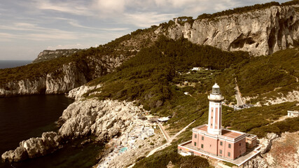 Lighthouse and Beach of Capri in summer season. View from a moving drone.