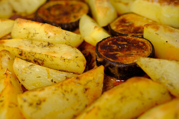 appetizing potatoes, eggplant slices baked in the oven, lying on a baking sheet, the concept of home cooking, traditional dishes