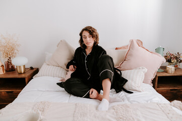 Delicate woman in pajama sitting in bed