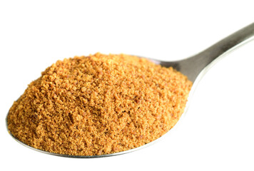 Coconut Sugar in a Spoon. Isolated on White. Dehydrated Sap of the Coconut Palm Tree.
