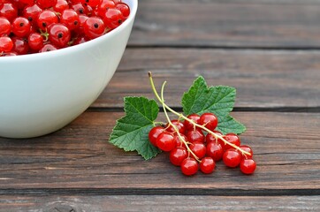 Bunch of ripe red currant on an old wooden table. Healthy eating concept.