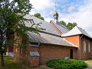 A wooden belfry and a brick chapel from the 16th century and a wooden Catholic church of Saint Zygmunt added to it in the 18th century in the town of Kraszewo in Mazovia, Poland.