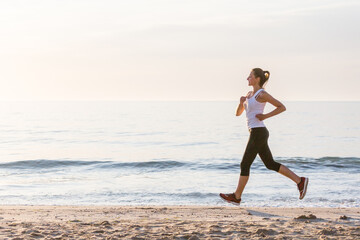 Beautiful woman running by the sea