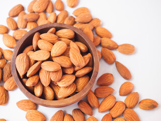 Seed of Almonds in wooden bowl on white background. 