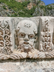 Masks and rock tombs in Myra, Turkey