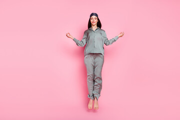 Photo of adorable shiny young lady sleepwear jumping high practicing yoga smiling isolated pastel pink color background