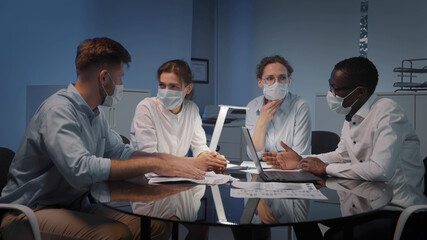 Interracial business team in safety mask brainstorm idea at office meeting room