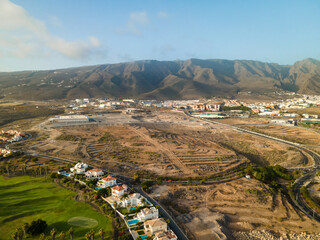 Naklejka premium Tenerife, a town on the Atlantic Ocean. Sunny coast and dry soil. Ocean, water, waves, blue ocean.