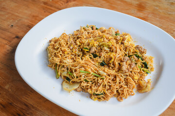Pad Thai with pork and vegetables in a bowl on the table
