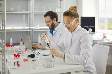 Female scientist making research in biochemical pharmaceutical lab analyzing new virus in blood....