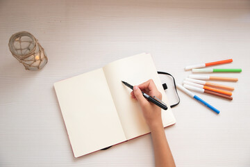 Niño escribiendo en una libreta tranquilamente. 