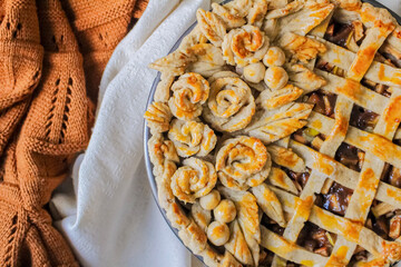 Autumn composition. Decorated apple pie on a table with flour and linen fabric. Blog, blogger and social media.
