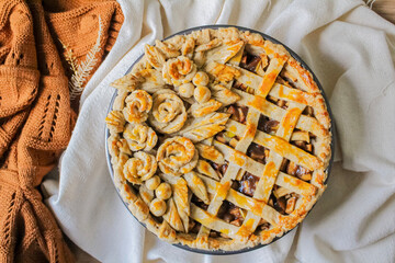Autumn composition. Decorated apple pie on a table with flour and linen fabric. Blog, blogger and social media.