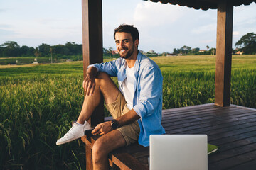 Smiling male freelancer working on laptop on terrace