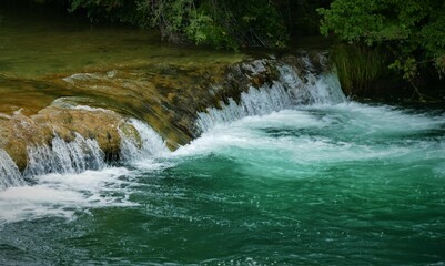 Green clean river with waterfalls nature background
