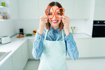 Photo portrait woman in apron childish looking in paprika slices smiling
