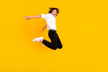 Full body profile photo of cool little brunet boy jump wear uniform isolated on yellow color background