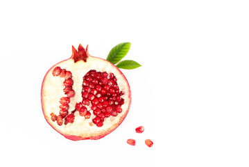 one half of a pomegranate with leaves lies on a white background