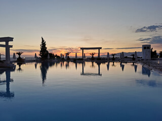 Fototapeta na wymiar Beautiful sunset over the empty pool and the sea. The Aegean sea. Turkey, Kusadasi.