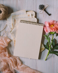 paper notebook on vintage papers, toned photo, pink peony, vintage key, top view, selective focus, copy space for text