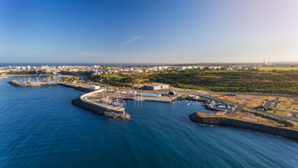 Fototapeta na wymiar Aerial. The maritime dock in the Portuguese city of Sines and the sailboat is moored for tourist excursions. Blue ocean. Sanny day